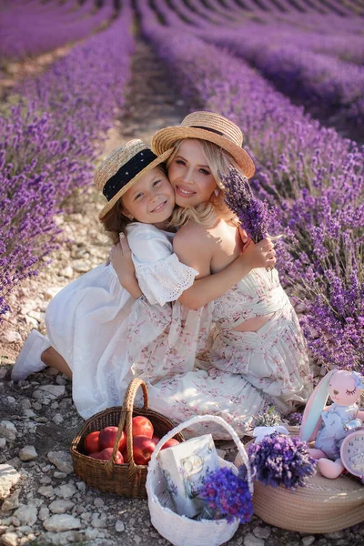 Vrouw met dochter in witte jurken hebben plezier in lavendelveld in de zomer. familieportretten — Stockfoto