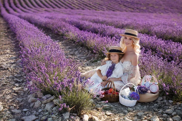 Frau mit Tochter in weißen Kleidern amüsiert sich im Sommer im Lavendelfeld. Familienporträts — Stockfoto