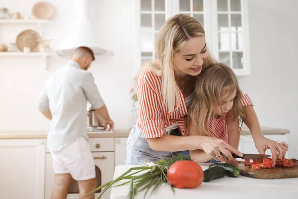 Sevimli küçük kız ve güzel ailesi mutfakta yemek pişiriyor. — Stok fotoğraf