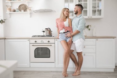 Yakışıklı adam ve çekici genç kadın mutfakta birlikte eğleniyorlar. Sağlıklı yaşam tarzı kavramı.
