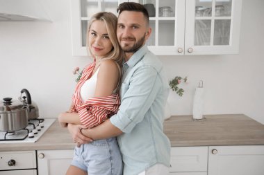 Yakışıklı adam ve çekici genç kadın mutfakta birlikte eğleniyorlar. Sağlıklı yaşam tarzı kavramı.