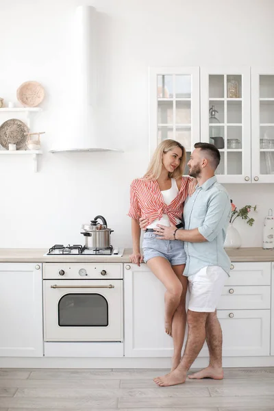 Kjekk mann og attraktiv ung kvinne har det gøy sammen på kjøkkenet. Frisk livsstil. – stockfoto