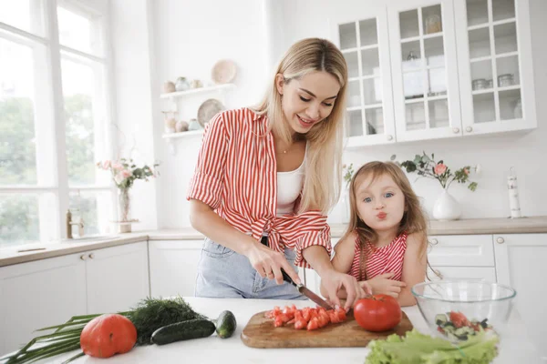 Sevimli küçük kız ve güzel annesi White Home 'un mutfağında yemek pişiriyorlar. — Stok fotoğraf