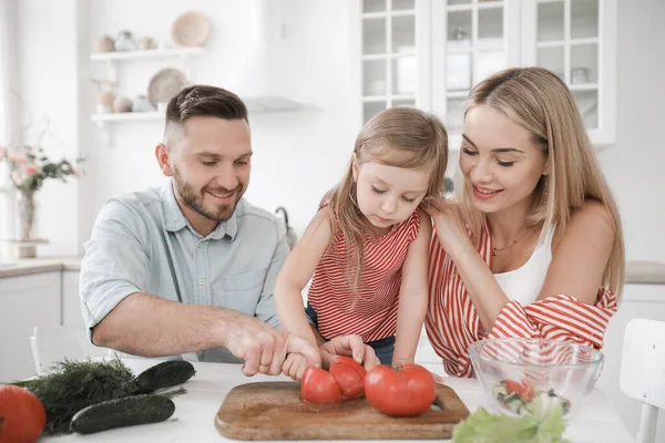 Sevimli küçük kız ve güzel ailesi mutfakta yemek pişiriyor. — Stok fotoğraf