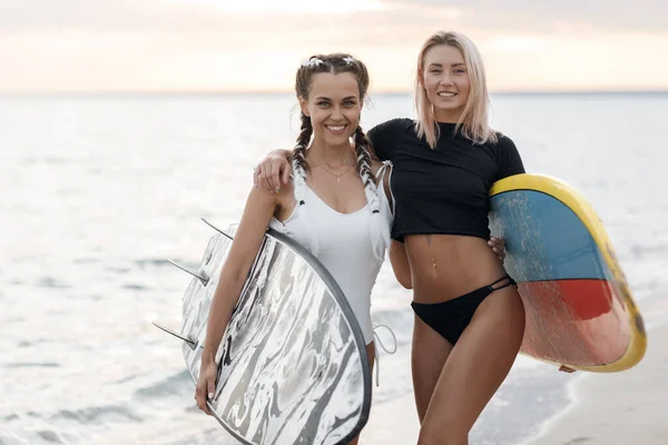 Deux jeunes belles femmes amies avec des planches de surf sur la plage — Photo