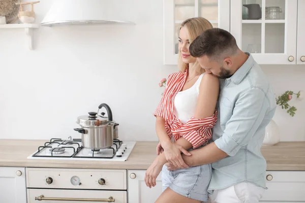 Handsome man and attractive young woman are having fun together in kitchen. Healthy lifestyle concept. — Stock Photo, Image