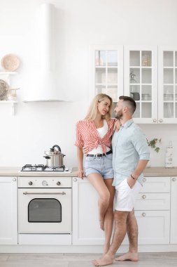Yakışıklı adam ve çekici genç kadın mutfakta birlikte eğleniyorlar. Sağlıklı yaşam tarzı kavramı.