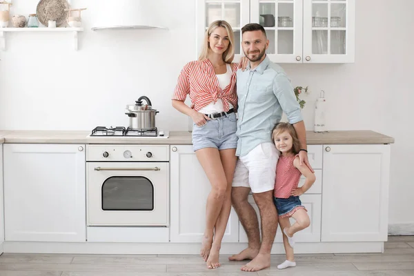 Familia feliz con hija en ropa casual en casa en la cocina — Foto de Stock