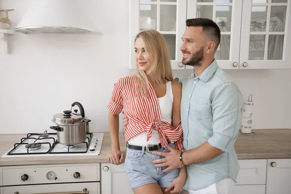 Un bel homme et une jolie jeune femme s'amusent ensemble dans la cuisine. Concept de mode de vie sain. — Photo