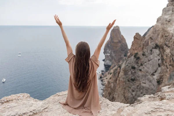 Jolie femme sur le bord sur la montagne sur fond de mer et ciel. nature estivale. portrait de beauté — Photo