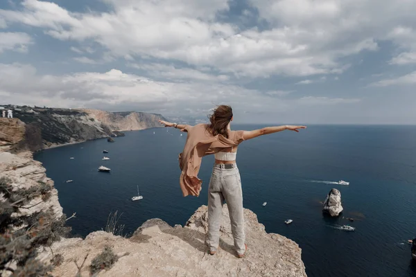 Pretty woman on the edge on mountain on sea and sky background. summer nature. beauty portrait — Stock Photo, Image