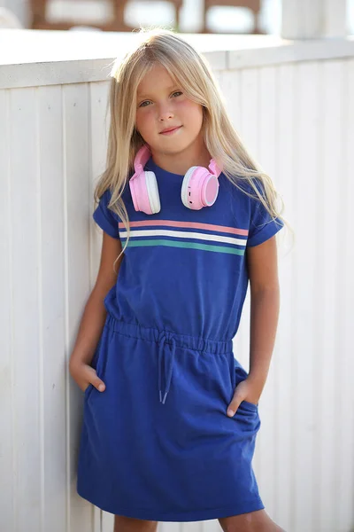 Muito menina pré-adolescente se divertindo ao ar livre com fones de ouvido no verão dia quente. — Fotografia de Stock