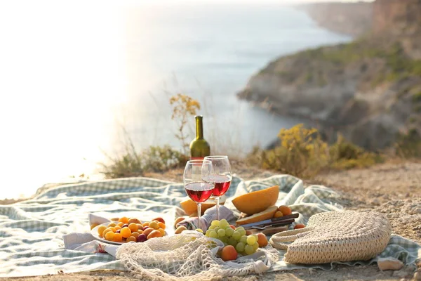 Picknick outdoors with fruits and wine by sea in naure — Stock Photo, Image
