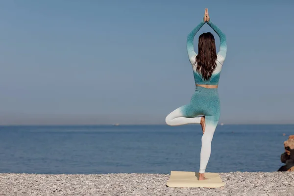 Кавказская девушка, практикующая йогу на берегу моря — стоковое фото