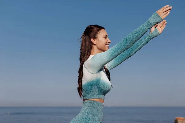 Mujer joven caucásica practicando yoga en la orilla del mar —  Fotos de Stock