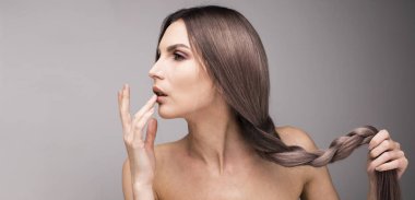 Seksi dudaklarını parmaklarıyla dokunarak uzun ve sağlıklı mor saçlı Genç bir kadın portresi.