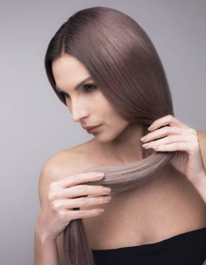 Güçlü uzun mor saçlı bir kadının dikey stüdyo çekimi.