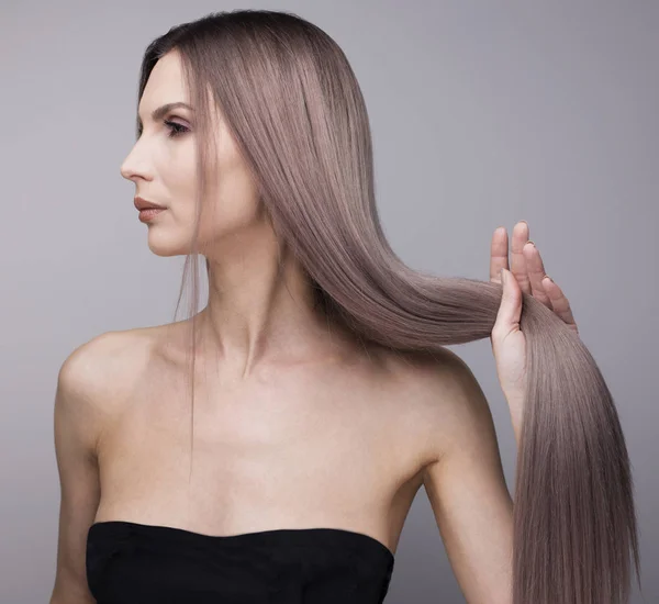 Sexy profile of a woman holding her perfect strong purple hair. — Stock Photo, Image