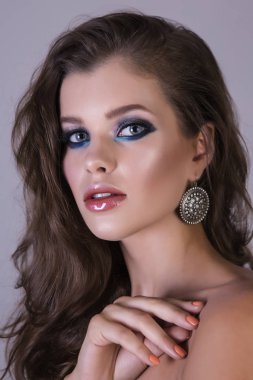 Renkli makyaj, doğal saç modeli ve ilginç küpe.