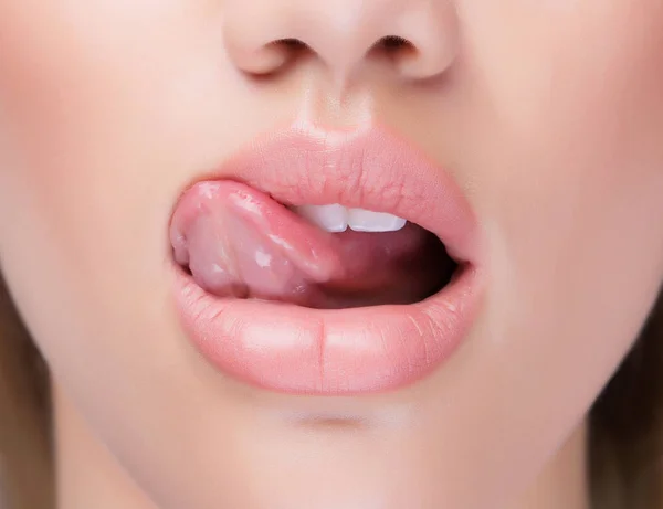 Närbild saftiga läppar med tungan slickar det. — Stockfoto