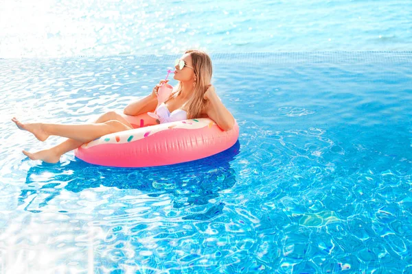 Zomervakantie. Vrouw in bikini op de opblaasbare donut matras in het zwembad van Spa. — Stockfoto