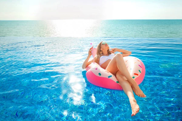 Férias de Verão. Mulher de biquíni no colchão inflável de donuts na piscina SPA . — Fotografia de Stock