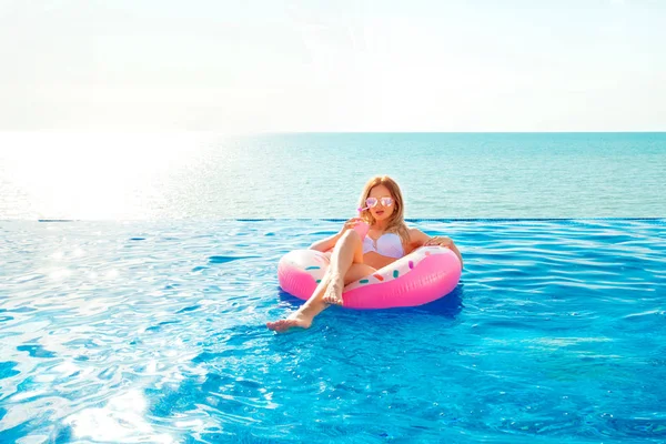 Summer Vacation. Woman in bikini on the inflatable donut mattress in the SPA swimming pool. — Stock Photo, Image