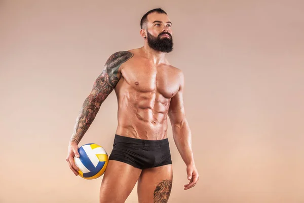 Kas genç fitness spor adamla güçlü vücut üzerinde ışık arka plan uygun. Voleybol kavramı. — Stok fotoğraf