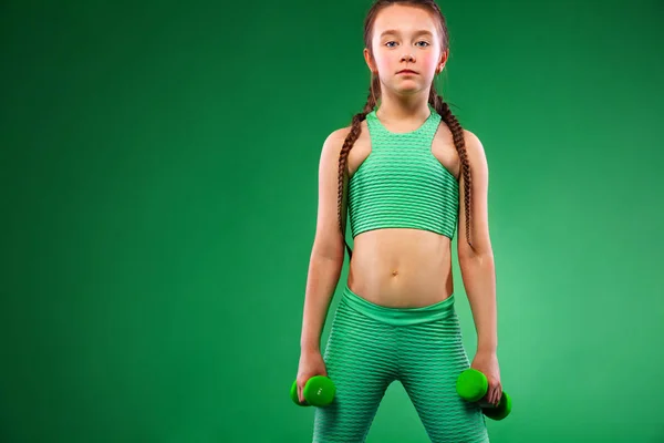 男孩女孩做健身运动与哑铃在绿色背景 — 图库照片