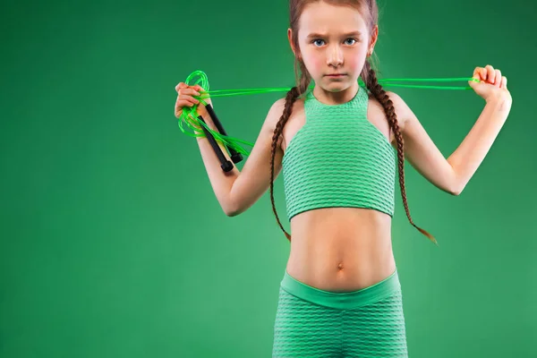 Menina fazendo exercícios de fitness no fundo verde — Fotografia de Stock