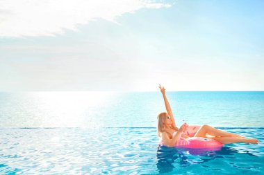 Yaz tatili. Bikini Spa yüzme havuzunda şişme çörek şişme kadın.