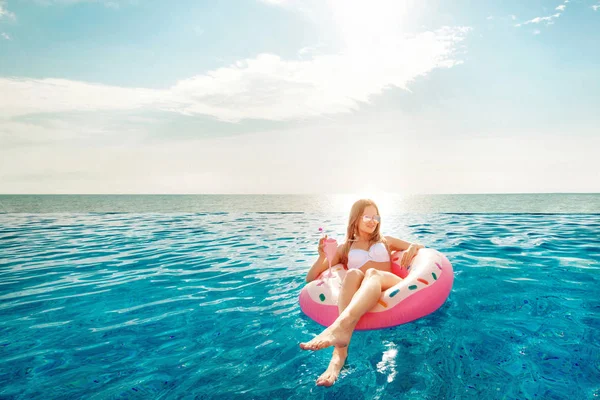 Summer Vacation. Woman in bikini on the inflatable donut mattress in the SPA swimming pool. Beach at the blue sea. — Stock Photo, Image
