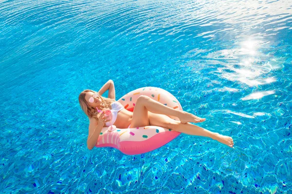 Férias de Verão. Mulher de biquíni no colchão inflável de donuts na piscina SPA . — Fotografia de Stock