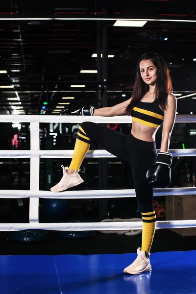 Mujer atleta joven en guantes de boxeo de pie en el anillo — Foto de Stock