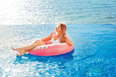 Yaz tatili. Bikini Spa yüzme havuzunda şişme çörek şişme kadın. Mavi deniz, plaj.