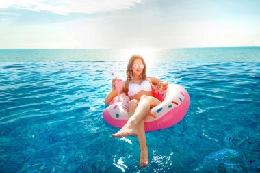 Yaz tatili. Bikini Spa yüzme havuzunda şişme çörek şişme kadın.