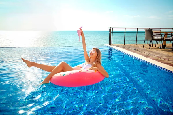 Summer Vacation. Woman in bikini on the inflatable donut mattress in the SPA swimming pool. — Stock Photo, Image