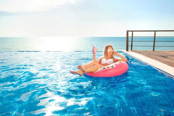 Vacaciones de verano. Mujer en bikini en el colchón inflable de la dona en la piscina SPA . — Foto de Stock
