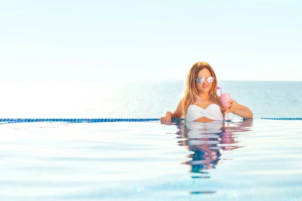 Sommerferien. Frau im Bikini auf der aufblasbaren Donut-Matratze im Wellness-Pool. — Stockfoto