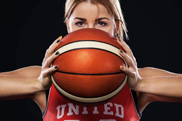 Retrato de uma menina bonita e sexy com um basquete em estúdio. Esporte conceito isolado no fundo preto . — Fotografia de Stock