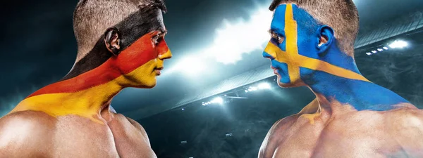 Deutschland vs Sverige. Two soccer or football fans with flags face to face on stadium. — Stock Photo, Image