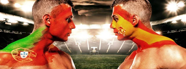 Portugalia vs Hiszpania. Dwóch kibiców piłki nożnej i piłki nożnej z flagami twarzą w twarz na stadion. — Zdjęcie stockowe