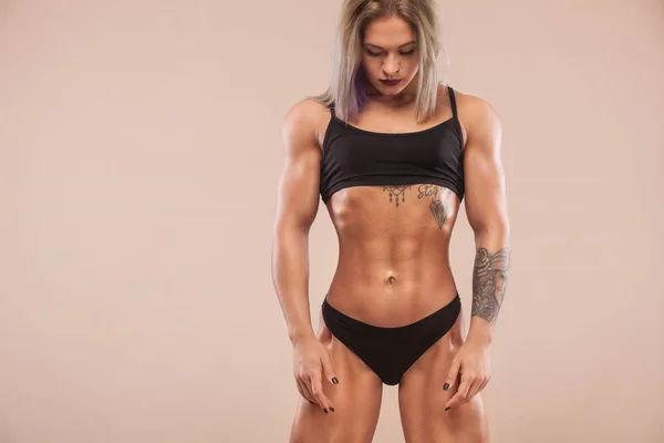 Muscle unga fitness sport kvinna med stark vältränad kropp på ljus bakgrund. — Stockfoto