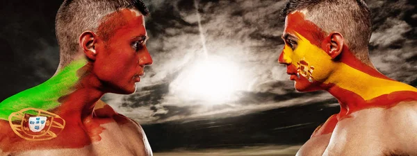 Portugal vs Spain. Two soccer or football fans with flags face to face on stadium. — Stock Photo, Image