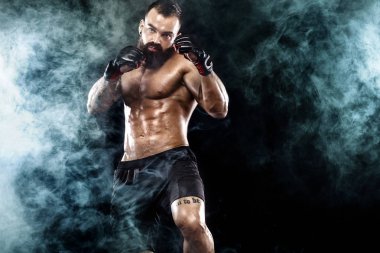 Boks kafesinde sokak dövüşçüsü. Işıklı ve dumanlı bir arka plan. Kopyalama alanı ile eylem görüntüsü.