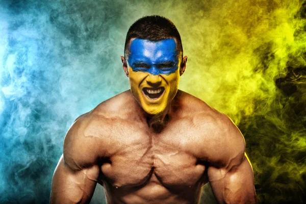 Fotboll eller fotboll eller volleyboll, fläkt med bodyart på ansiktet - flagga Ukraina. — Stockfoto