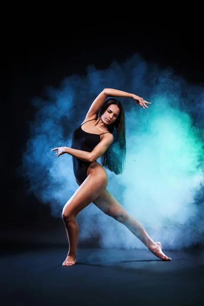 Bela jovem e ajuste dançarina de balé pulando em um fundo preto. Conceito de dança e desporto . — Fotografia de Stock