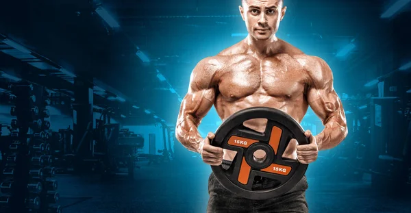 Acımasız güçlü kas vücut geliştirmeci atletik erkek yakışıklı erkekler spor salonu çıplak gövde egzersizleri yapıyor kaslar egzersiz vücut geliştirme kavramı arka plan - pompa. Spor beslenme reklamlar için kopya alanı.