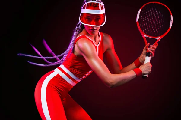 Tennis player. Beautiful woman athlete with racket in red costume and hat isolated on black background. Fashion and sport concept. — Stock Photo, Image