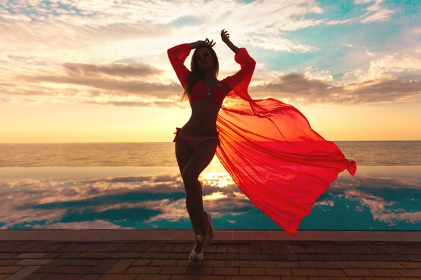 Zomervakantie. Silhouet van de dansende vrouw schoonheid op zonsondergang in de buurt van het zwembad met uitzicht op de Oceaan. — Stockfoto